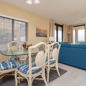 Dine comfortably at the glass-top table surrounded by stylish chairs, with beautiful views just beyond the windows