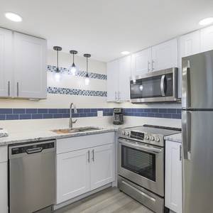 Stylish kitchen featuring stainless appliances, stylish lighting, and a sleek design, perfect for culinary adventures