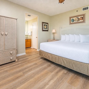 The king master suite welcomes you to rest with plush pillows and soothing coastal artwork