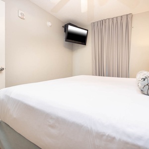 Enjoy a restful night on the king bed, complemented by a flat-screen TV and soft curtains for a cozy ambiance