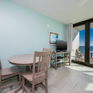 Enjoy meals at the round dining table while taking in the view through large glass balcony doors that open to the beach