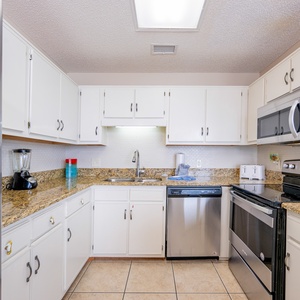 Modern kitchen featuring white cabinetry, granite countertops, and a breakfast bar for convenient entertaining