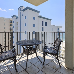 Balcony seating with a round table offers a relaxing spot to enjoy views of the beach and the gentle waves of the gulf