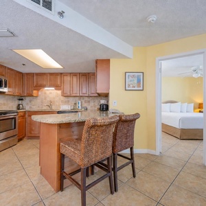 The kitchen's breakfast bar with woven stools invites casual chats as smells from cooking fill the air
