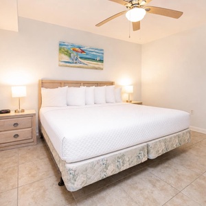 Unwind in the spacious bedroom featuring a king-sized bed, soft linens, and serene coastal artwork