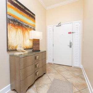 Brightly decorated entryway featuring a stylish console table, modern lamp, and vibrant artwork, welcoming you home