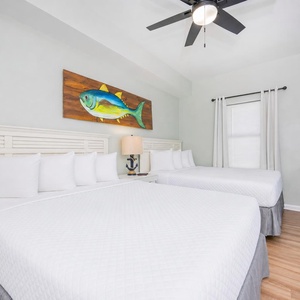 Two queen beds in the guest suite invite you to rest deeply after a day of coastal fun and streaming shows on TV