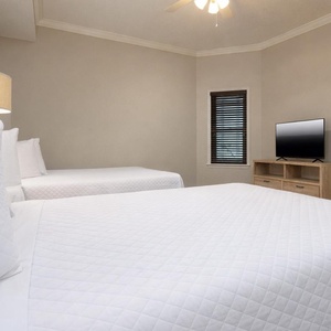 Inviting guest bedroom featuring a two cozy double beds and a TV