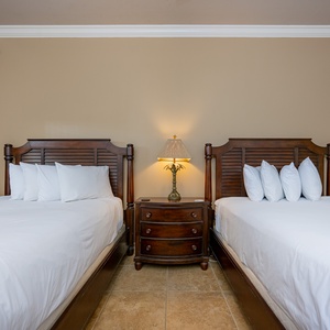 Rest peacefully in this guest room with two queen beds, soft lighting, and a cozy vibe perfect for relaxing