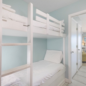 This cozy nook features a charming bunk bed and a bright, beachy decor, perfect for family fun and relaxation