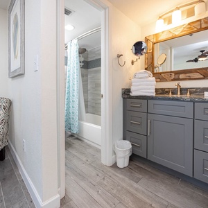 Master bathroom featuring a stylish vanity, plush towels, and a relaxing tub/shower combo with a vibrant curtain