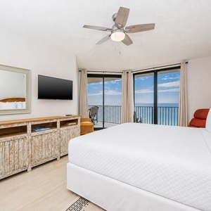 Spacious master suite with a king bed, TV, and beachfront balcony access