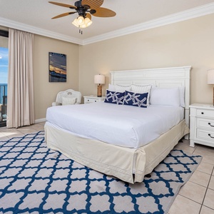 Unwind in this inviting master suite featuring a plush king bed, coastal decor, and direct access to beautiful beach views