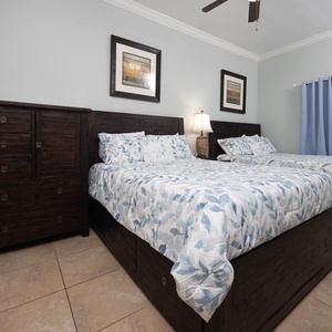 Rest in this inviting guest bedroom with two queen beds, decorative linens, and stylish furnishings
