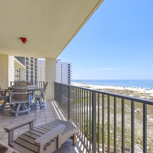 Relax on the balcony with comfortable seating, enjoying a peaceful view of the beach and sparkling gulf waters