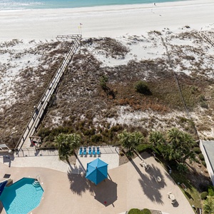 Relax by the poolside under a shaded cabana, with easy access to the beach and inviting lounge chairs nearby