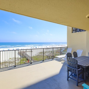 Enjoy beach breezes from the spacious extended balcony with a dining table and lounge chairs overlooking the serene beach