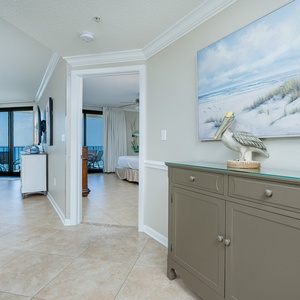 Step into a welcoming entryway featuring coastal decor and a view of the inviting living area and beach beyond