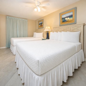 Rest comfortably in this welcoming guest bedroom featuring two double beds, soft linens, and charming decor