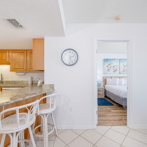 Bright kitchen featuring wooden cabinetry, a granite countertop, and a breakfast bar with seating, leading to the master