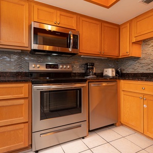 This kitchen features stainless appliances, granite countertops, and a coffee maker for a delightful cooking experience