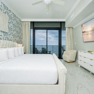 Relax in the master bedroom featuring a king bed, stylish decor, and beachfront balcony access