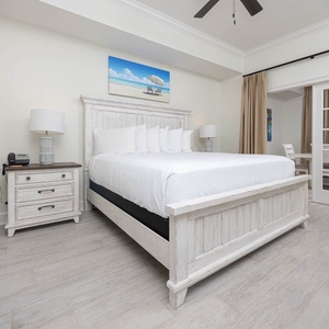 The master bedroom features a white king bed, soft linens, and a cozy reading nook, perfect for relaxation and comfort