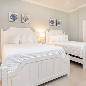 Retreat to this charming guest suite with two queen beds, stylish accents, and soft lighting