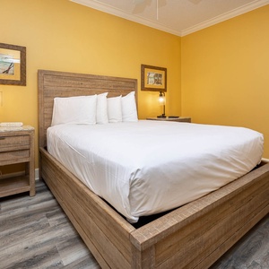 Retreat to this inviting guest bedroom featuring a queen bed, warm yellow walls, and stylish decor for a restful night