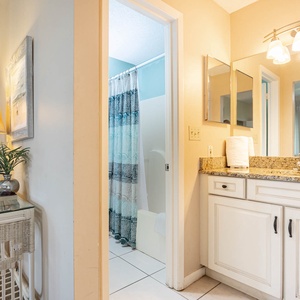 Step into this master bathroom featuring a granite countertop, stylish lighting, and a relaxing shower area
