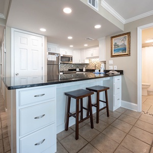 This kitchen features sleek granite countertops, stainless appliances, and a cozy breakfast bar, perfect for casual dining