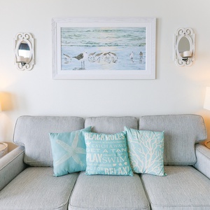 Savor relaxed evenings on the plush sofa, surrounded by charming coastal decor and warm lighting