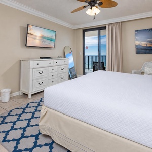 Enjoy restful nights in this inviting master bedroom with a king bed, a TV, and a view that opens to the beachfront balcony