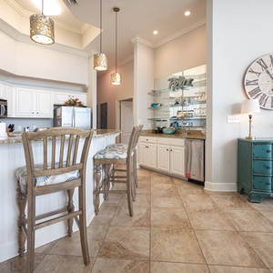 The coastal kitchen features stainless appliances, granite countertops, and stylish lighting, perfect for culinary adventures