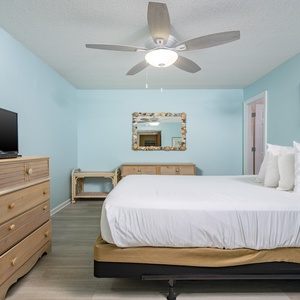 This guest bedroom features a cozy atmosphere with a comfortable bed, a TV, and soft blue walls, perfect for relaxation
