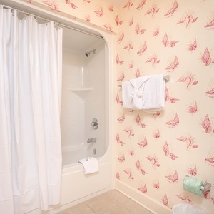 Escape daily routines in the guest bath, where a relaxing soak awaits in a tub adorned with coastal flair