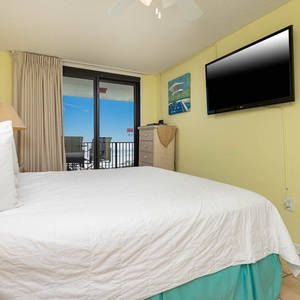Brightly colored walls complement the king bed in the master, while a sliding door reveals a balcony with beach views