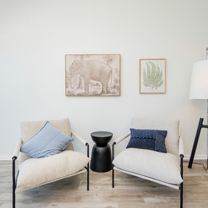 Master seating area featuring stylish chairs, modern decor, and a breathtaking view of the coastline