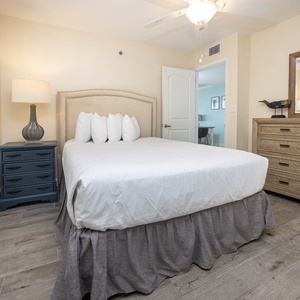Cozy guest bedroom featuring a plush queen bed with decorative pillows and stylish furnishings, perfect for a restful retreat