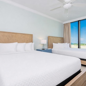Tranquil guest bedroom featuring two comfortable queen beds and large windows offering stunning views