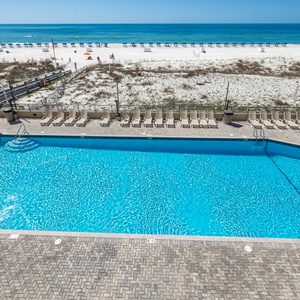 Enjoy the inviting pool area with plenty of lounge chairs, just steps away from the beach and sparkling waters