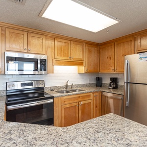 Cook and gather in this spacious kitchen featuring granite countertops, stainless appliances, and wooden cabinetry