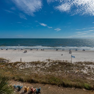 This inviting view showcases a beautiful beach with colorful umbrellas and chairs, perfect for a relaxing getaway