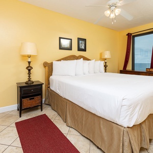 Inviting master bedroom featuring a king bed, elegant decor, and large windows showcasing a beautiful coastal view