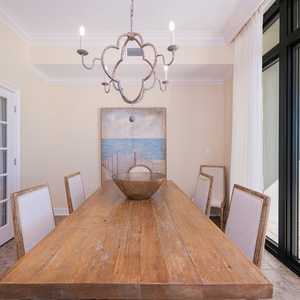 Gather at the long dining table, where warmth and coastal views create the perfect backdrop for family bonding
