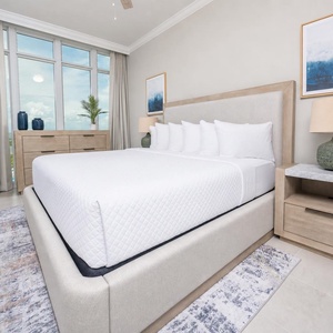 Relax on the cozy king bed in this guest suite and unwind with coastal views after a beach day