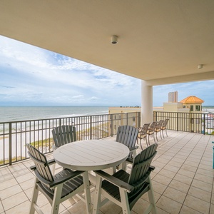 Relax on the expansive balcony with inviting seating and enjoy breathtaking views of the pristine beach and tranquil waters