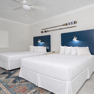 Charming queen guest suite with stylish headboard lighting and coastal accents
