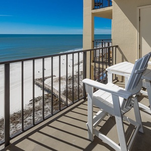 Relax on the private balcony with white chairs, overlooking the serene serene beach and tranquil blue waters