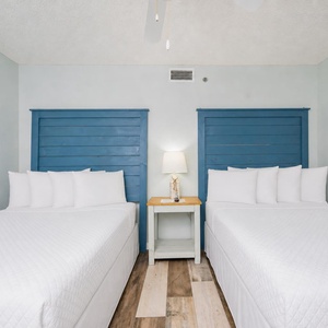 Soft bedding invites restful nights between the two double beds in the cozy guest suite